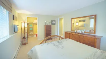 Royal Crest Estates Marlboro master bedroom with walk-in closet – Large primary bedroom featuring queen bed, dresser, and attached walk-in closet with shelving.