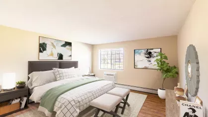Royal Crest Estates Marlboro master bedroom with modern furnishings – Stylish bedroom with large bed, modern furniture, artwork, and big window overlooking community green space.