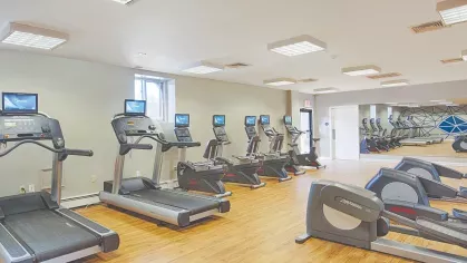 Fitness room with cardio machines – Spacious gym featuring ellipticals, treadmills, and large mirrors at Royal Crest Estates Marlboro.