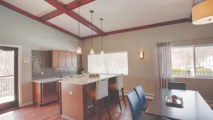 Community kitchen at Royal Crest Estates Marlboro featuring modern cabinetry, pendant lighting, large island with seating, and dining area with windows