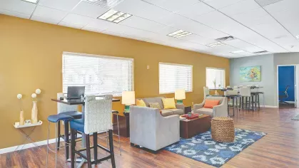 Resident lounge at Royal Crest Estates Marlboro with contemporary seating, wood-style floors, workstations, and large windows for natural light