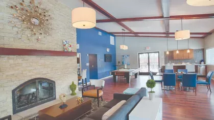 Spacious clubhouse at Royal Crest Estates Marlboro with stone fireplace, pool table, modern seating, and open kitchen area