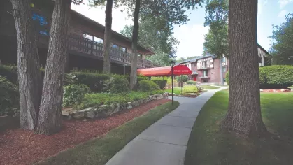 Community fitness center with red awning along landscaped walking paths at Royal Crest Estates Marlboro.