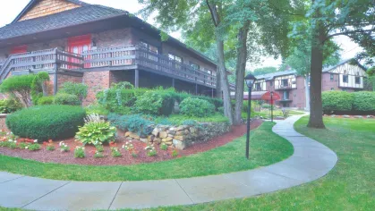 Royal Crest Estates Marlboro clubhouse with landscaped gardens, stone retaining wall, and walking path