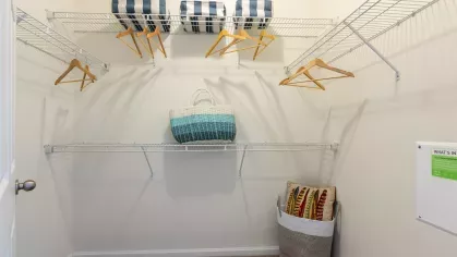 Large closet with multiple levels of shelving for storage. 