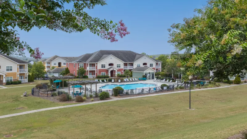 Market Street Station swimming pool with bright, green grass and trees surrounding.