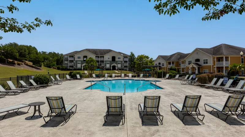 Lounge chairs conveniently located around the large swimming pool.