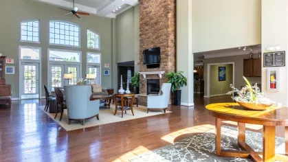 Bright, open clubhouse with large windows and an oversized fireplace.