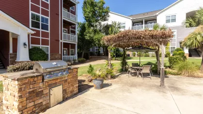 Outdoor grilling area with seating located under a large cabana. 