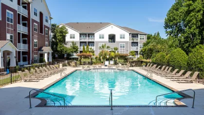 Resort style swimming pool with easy-access and lounge chairs for residents to relax.