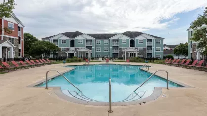 Sparkling, resort style swimming pool with ample seating for residents to enjoy. 