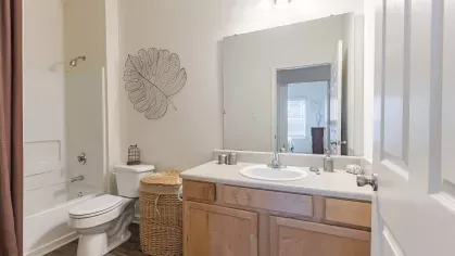 Upgraded bathroom with bright light fixtures and tub/shower combination. 