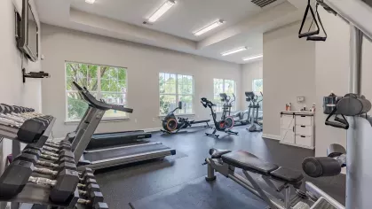 Bright fitness center with multiple machines and weights for residents to enjoy. 