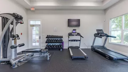 Fitness center with a TV, multiple machines and weights for residents to enjoy. 