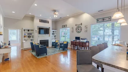 Clubhouse area with multiple seating options and the view of the community kitchen. 