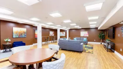 Resident lounge with modern artwork, cushioned seating, and warm lighting creating a welcoming atmosphere.