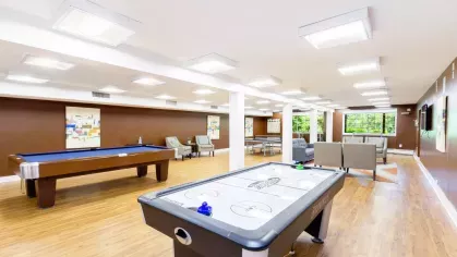 Game room featuring air hockey, billiards, and ping-pong tables with comfortable seating nearby.