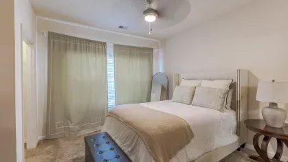 Large primary bedroom with overhead lighting and ceiling fans.