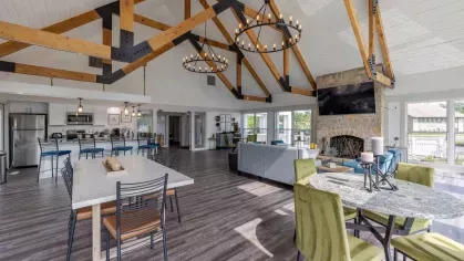 Large, expansive clubhouse with overhead lighting, large flatscreen TV, and multiple seating arrangements.
