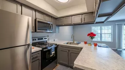 Bright, open kitchen with upgraded stainless steel appliances. 