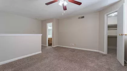 Open bedroom with overhead ceiling fan and light.