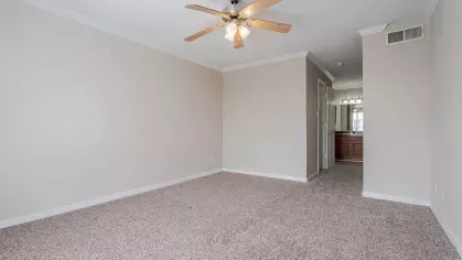 Open bedroom with overhead ceiling fan and light.