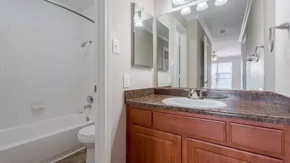 Bright, open bathroom with shower/tub combination.