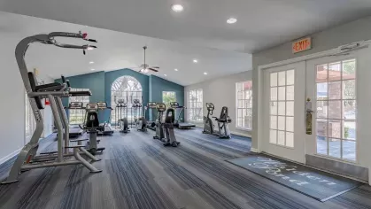 Open fitness center with ample lighting and machinery.