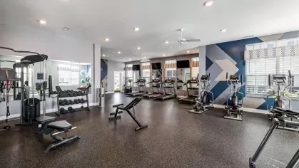 Fitness center with multiple machines and space for residents.