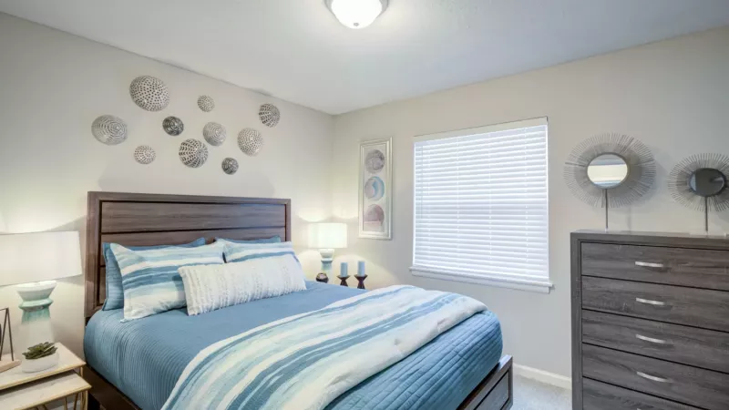 Open bedroom with bright overhead light and ample space.