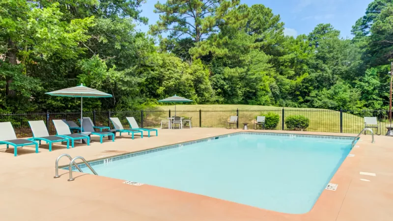 Sparkling, resort style swimming pool with ample seating for residents to enjoy. 