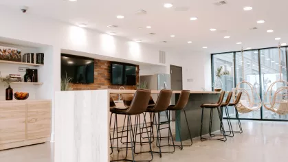 Clubhouse kitchen with ample bar seating and multiple TVs.