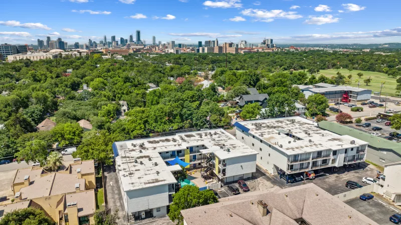 Arial shot of Miller Square, surrounded by luscious trees and greenery and a skyline view.