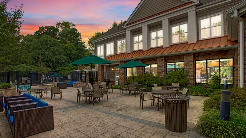 Outdoor tables located near the pool and fireplace.