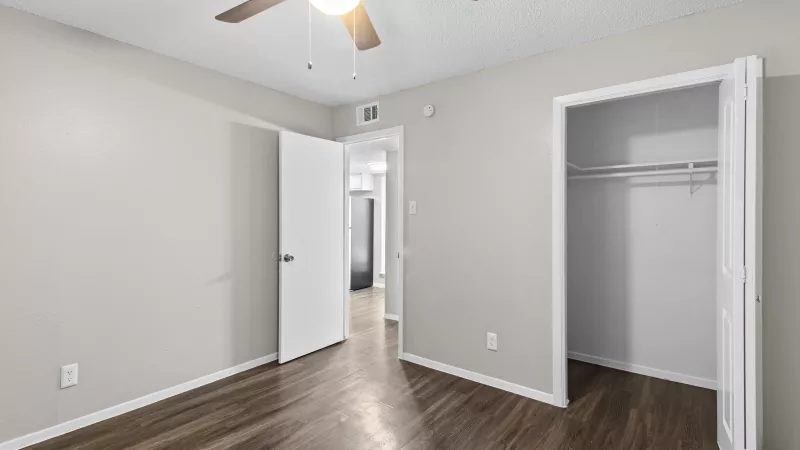 Large primary bedroom with overhead fan and light.