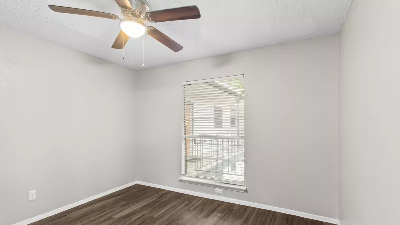 Large primary bedroom with overhead fan and light.