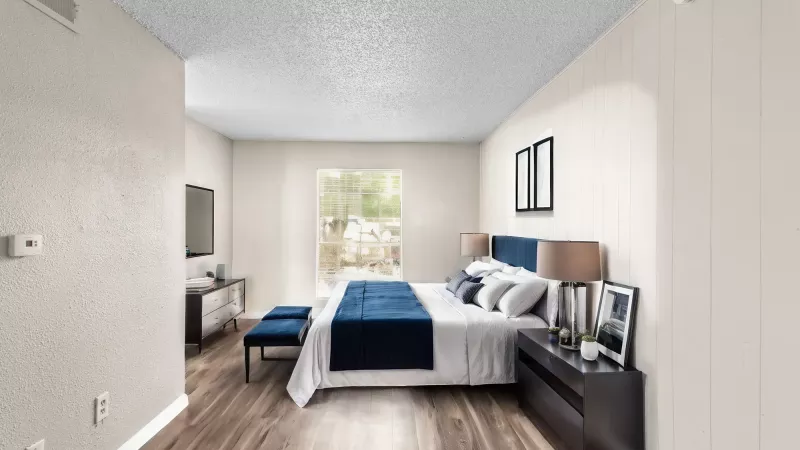 Large, bright bedroom with large window allowing for natural light.