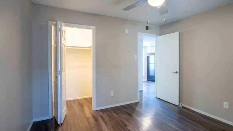 Bright bedroom with overhead light and ceiling fan.