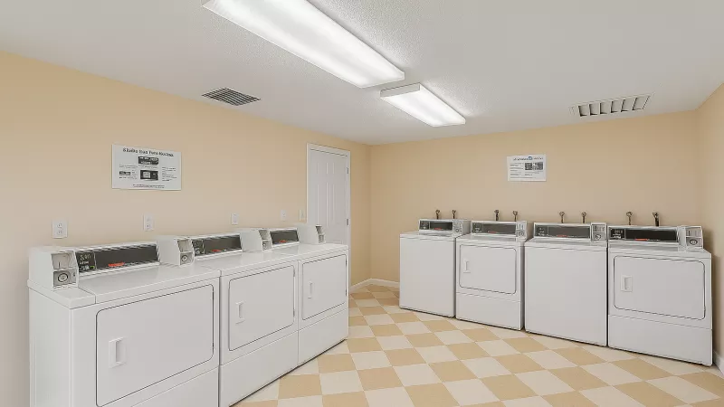 A clean laundromat with two rows of white washing machines and dryers. Beige walls and checkerboard floor.