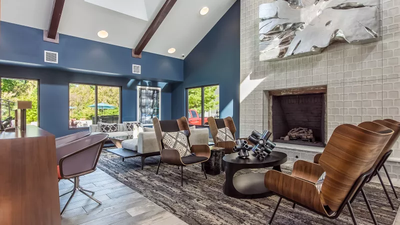 Modern lobby with blue walls, vaulted ceiling, fireplace, and stylish seating area.