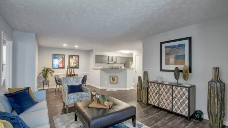 A spacious living room with modern decor, featuring a mix of neutral and vibrant colors for a cozy ambiance.