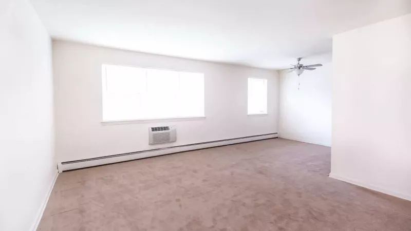 An open-concept kitchen and living room featuring carpeted floors and warm neutral tones for a welcoming environment.