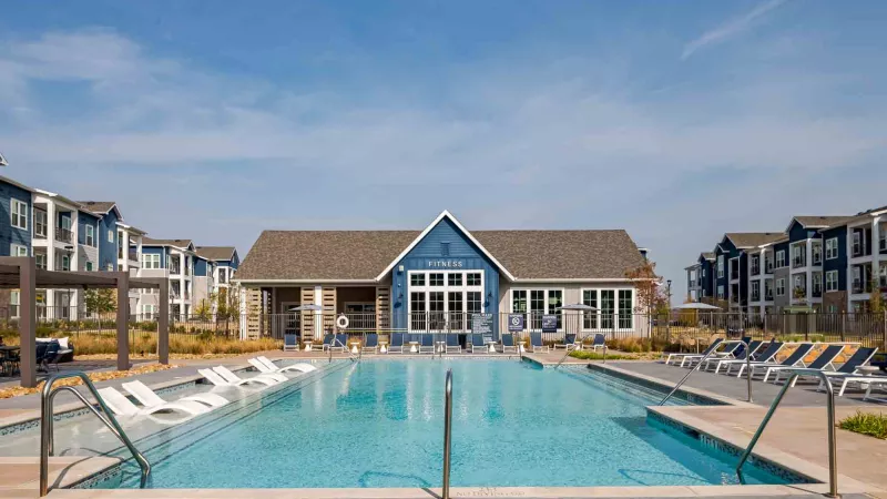 Sparkling, resort style pool with lounge chairs flanking both sides.