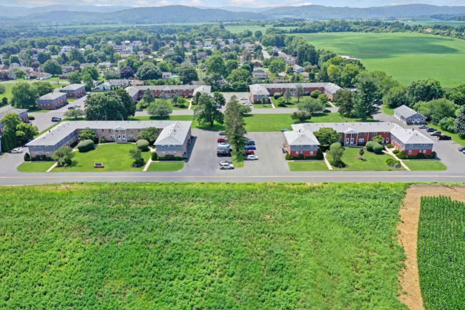 Aerial view showcasing the neat layout of residential units, courtyards, and surrounding fields.