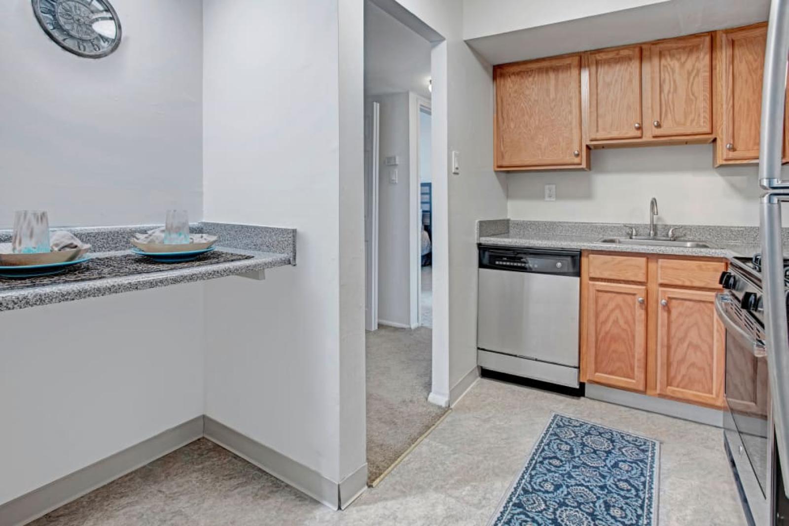 A compact dining nook with a granite breakfast bar set up with tableware.