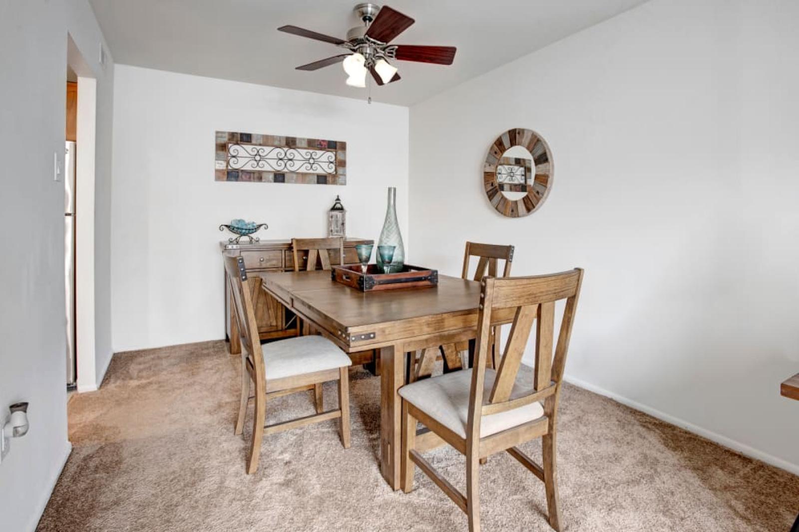 A cozy dining room with a rustic wooden table, chairs, and tasteful wall decor.
