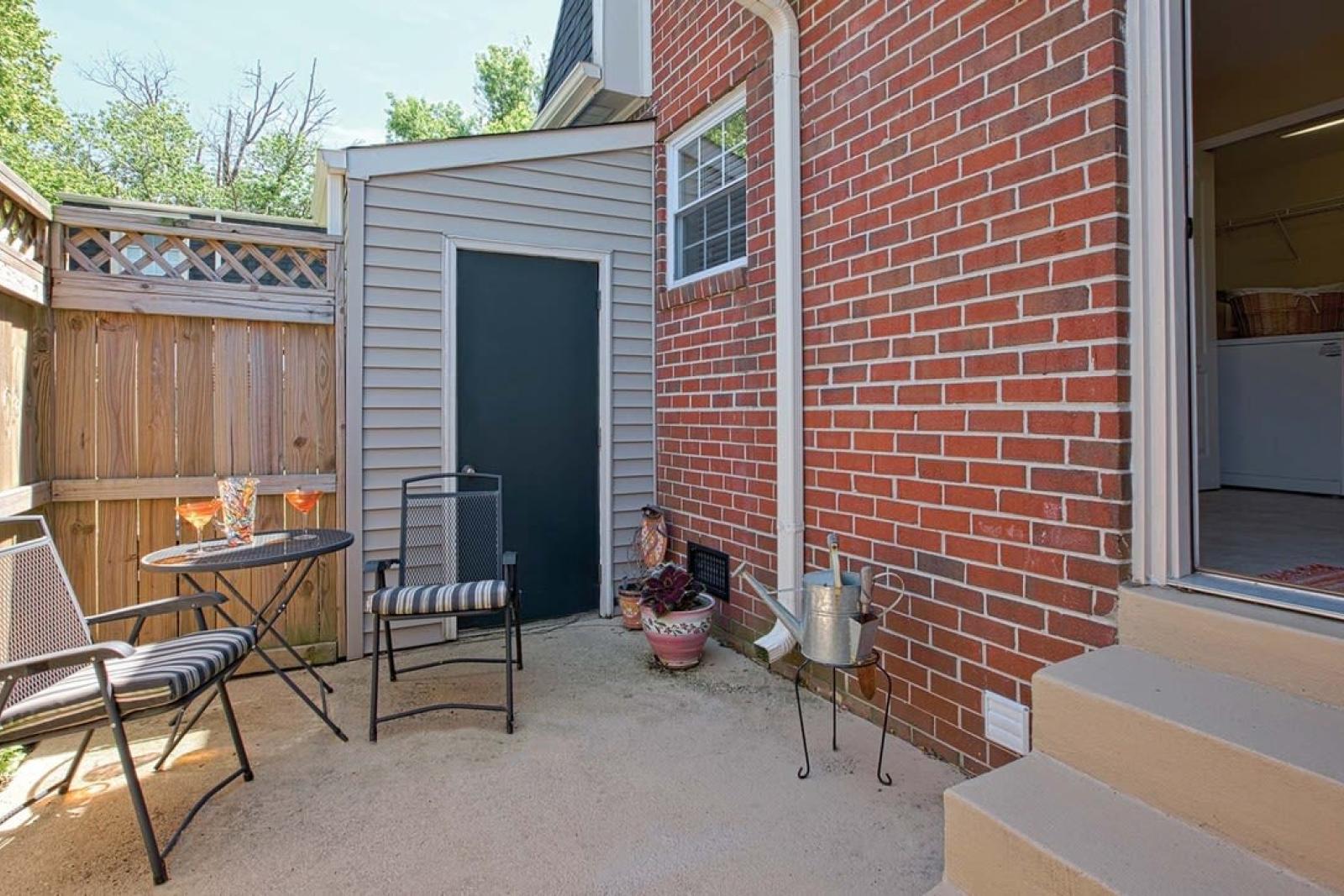 Private fenced-in patio space for outdoor enjoyment, featuring room for seating and potted plants.