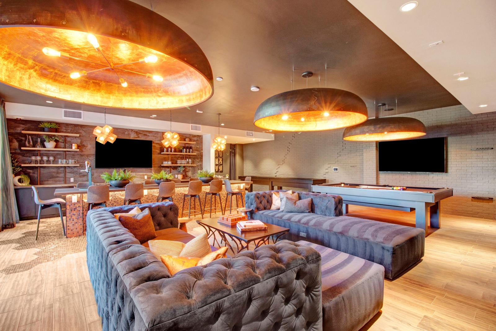 Elegant community space with a sleek bar setup, pendant lighting, and upscale décor for social gatherings and relaxation.
