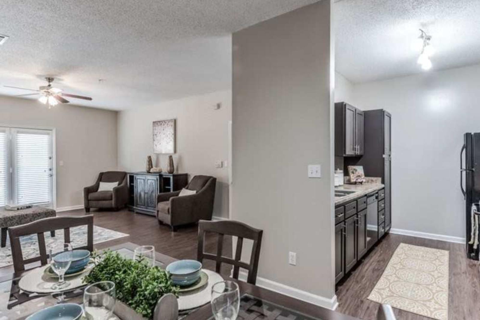 Spacious dining and living area with stylish decor, featuring a set dining table and comfortable seating.
