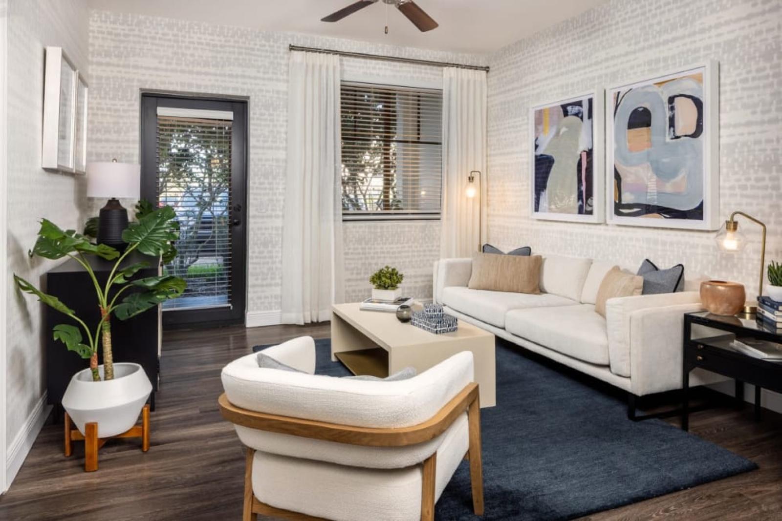 A spacious layout with a cozy seating area, sleek shelving, and a gourmet kitchen with stainless steel appliances and an island for casual dining.